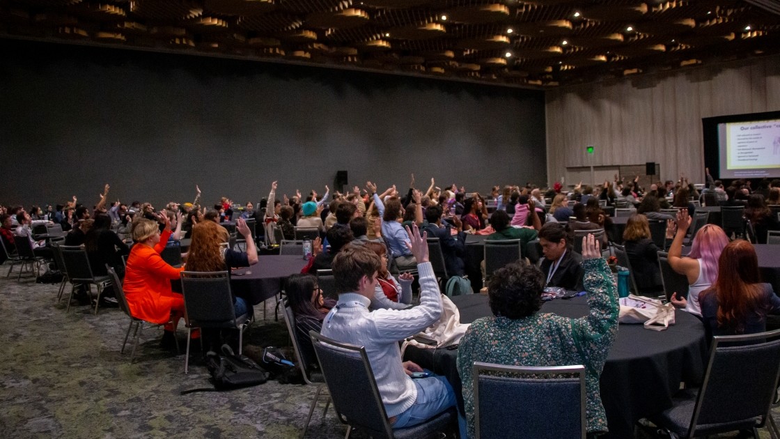Conference hall of people raising their hands