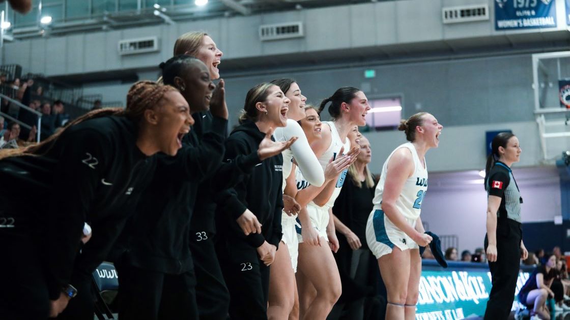 WWU Women's Basketball players cheering on their teammates from the sideline