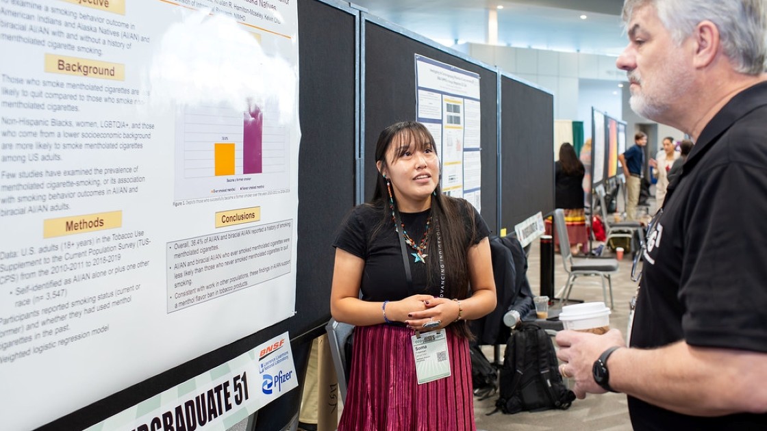 Indigenous student presenting research poster at AISES National conference