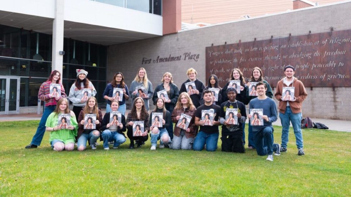 The Lumberjack staff posing with a previous magazine edition.