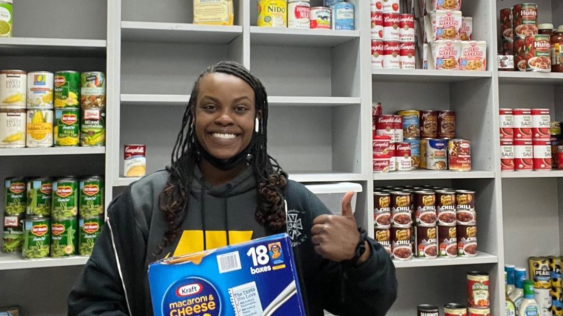 Food pantry worker named Tanay, helps to stock the shelves with donated food