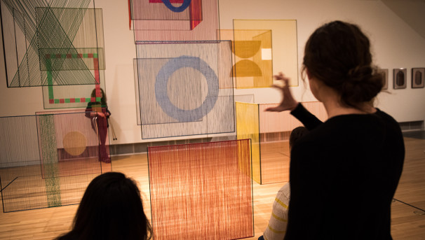 Two individuals in an art gallery, looking at a piece