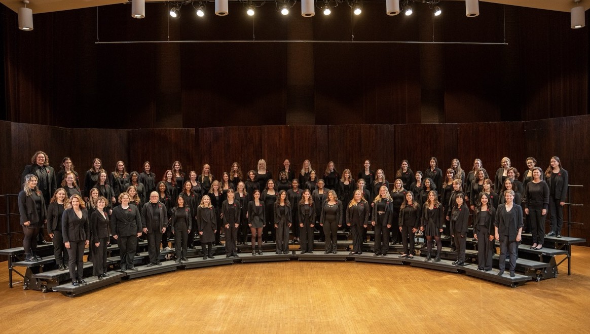 Women's Glee Club standing on risers for a picture on Weigel Stage