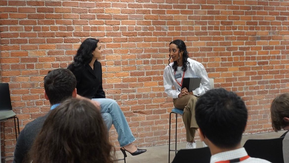Safa speaking with another woman in front of a crowd