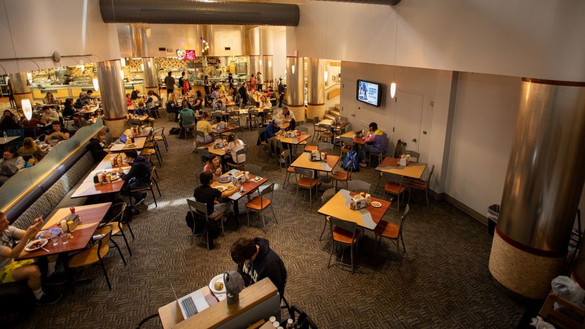 Students eating and studying inside an NAU dining hall.