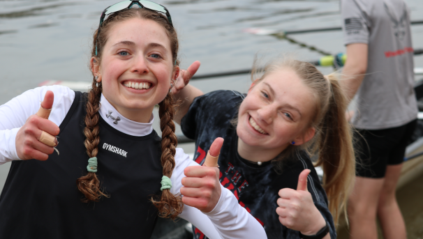 Two girls smiling with their thumbs up