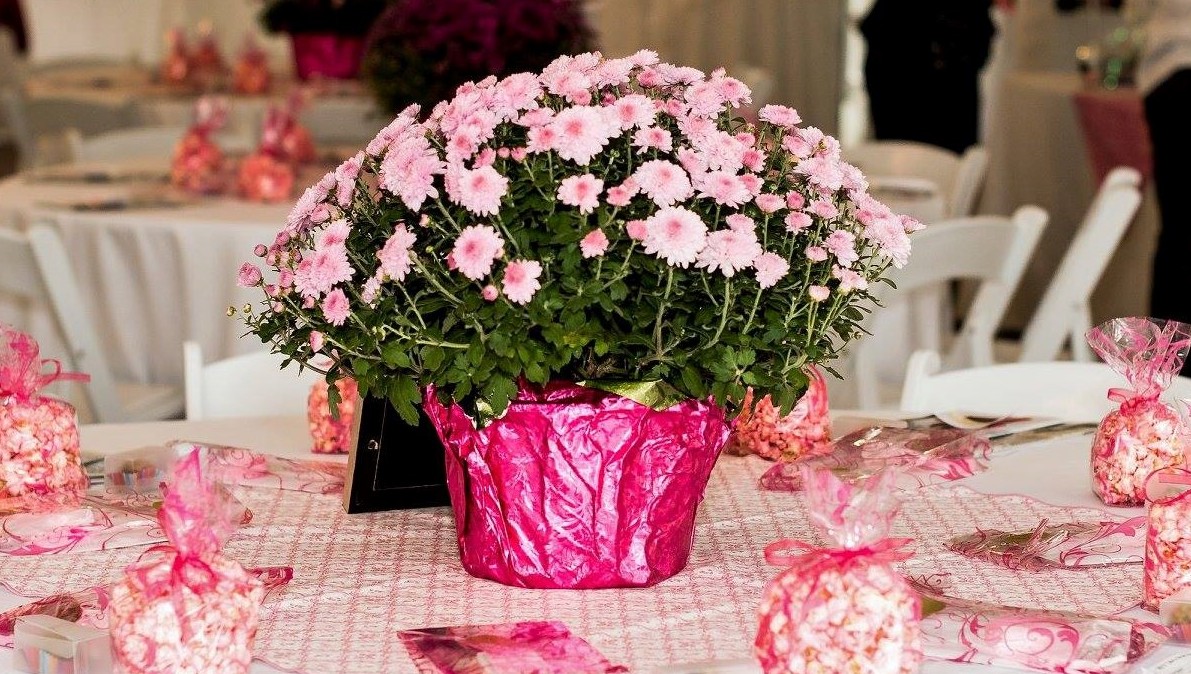 A large bouquet of light pink flowers in the center of a round table