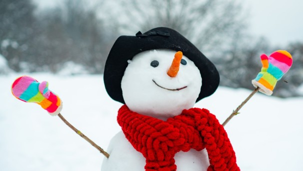 The top half of a snowman. It wears a red scarf, rainbow mittens, and a black hat.