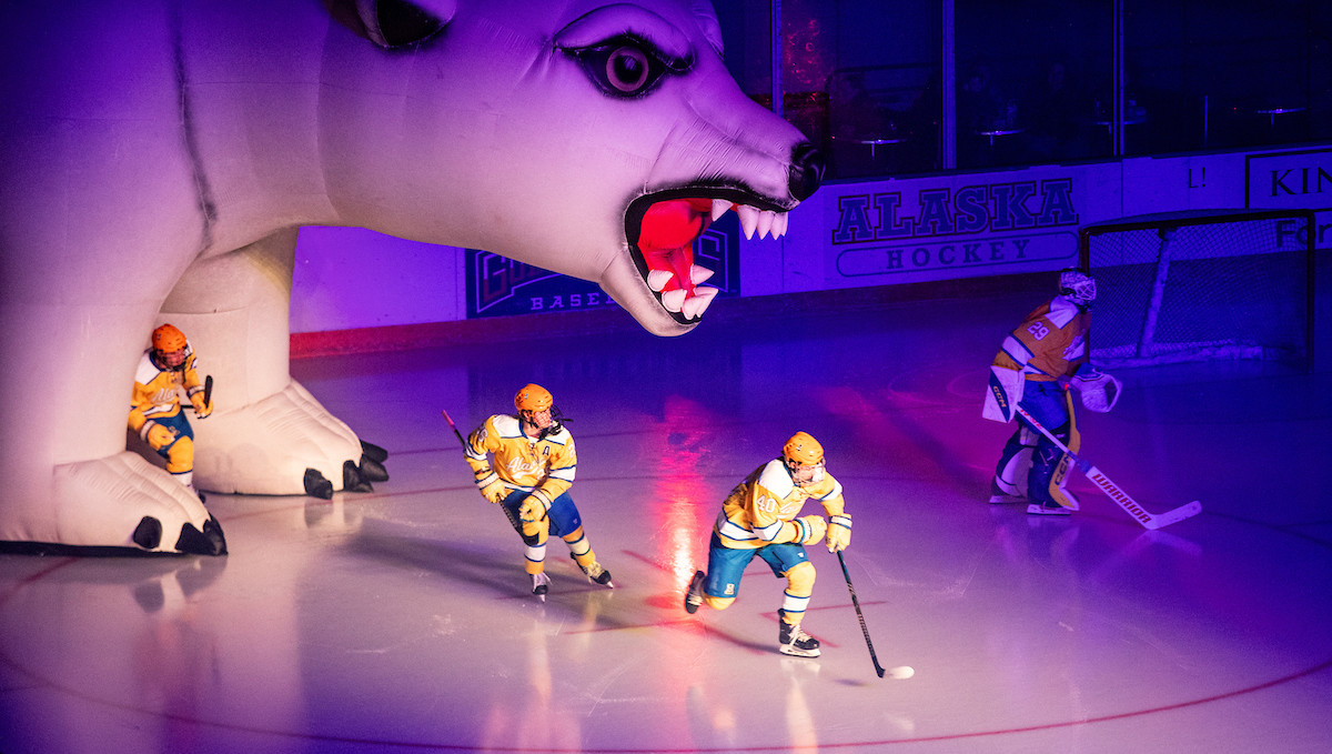 Nanooks take the ice in game against Denver University, skating through the inflatable Nanook.