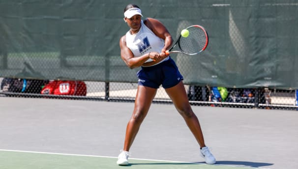 Monmouth Women's Tennis Student-Athlete making a backhand shot.