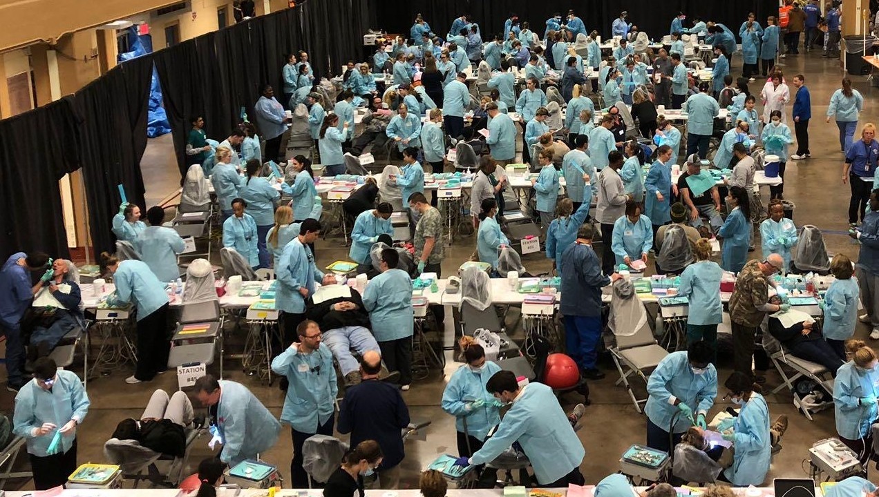 A nurse checking a patient's eyesight with a machine and her hand