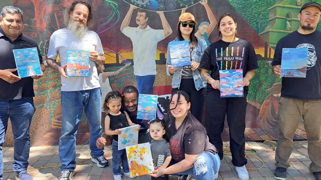 Group with paintings at mural.