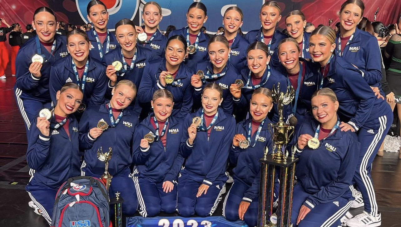 Dance team posing with medals at a competition