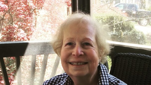 Individual smiling while sitting in an enclosed patio space