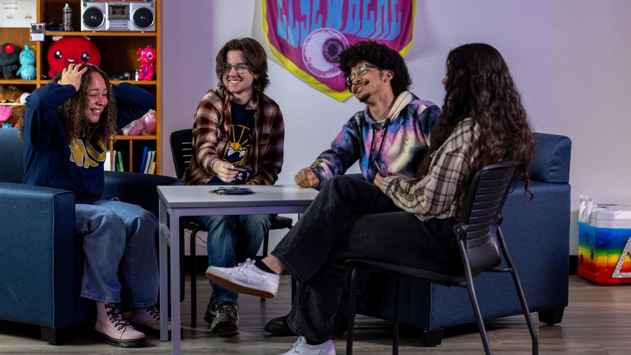 Students relaxing and playing a game together inside a campus lounge