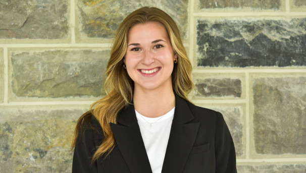 Alli smiles in front of Hokie Stone wall