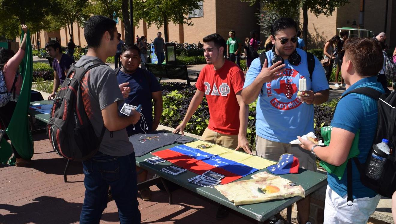 Image of fraternity members hosting a booth in front of Willis Library