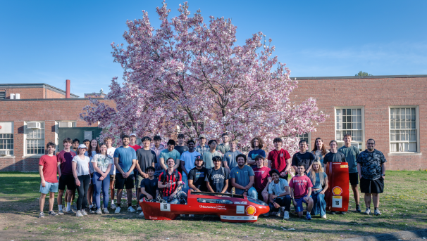 Team photo with vehicle