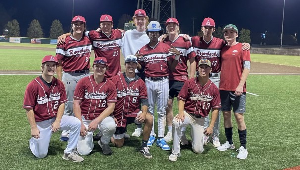 Members of the University of Arkansas club baseball team stand together on the baseball field