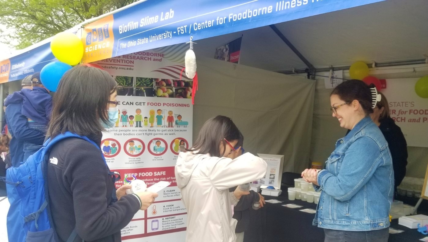 Volunteers speak with young students at their information booth during the COSI Science Festival