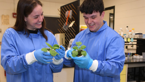 Two students holding plants