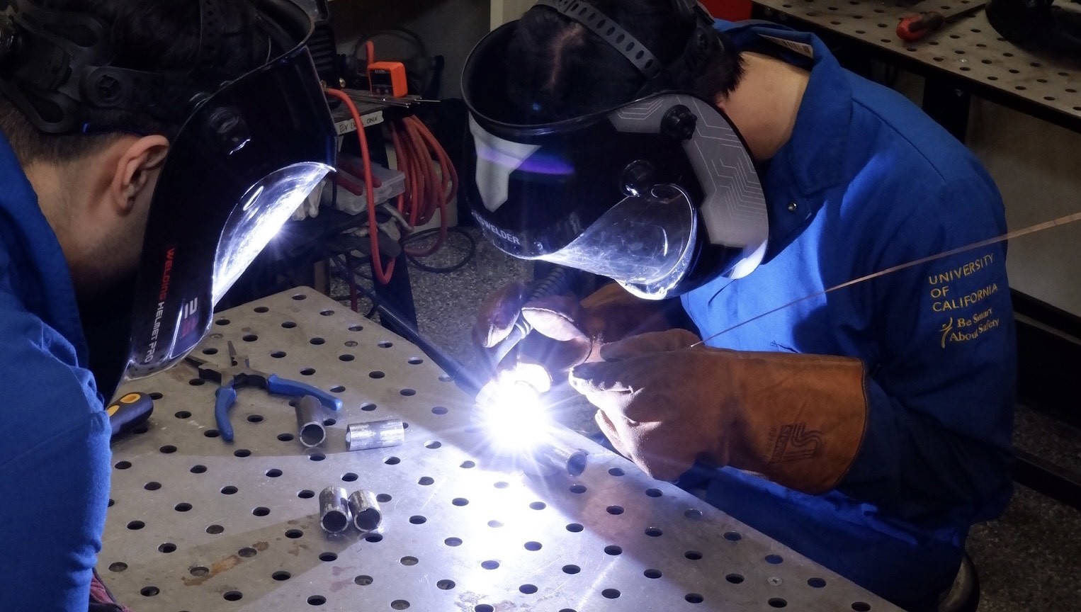 Precision at work — student engineers weld the chassis that will soon hit the track.