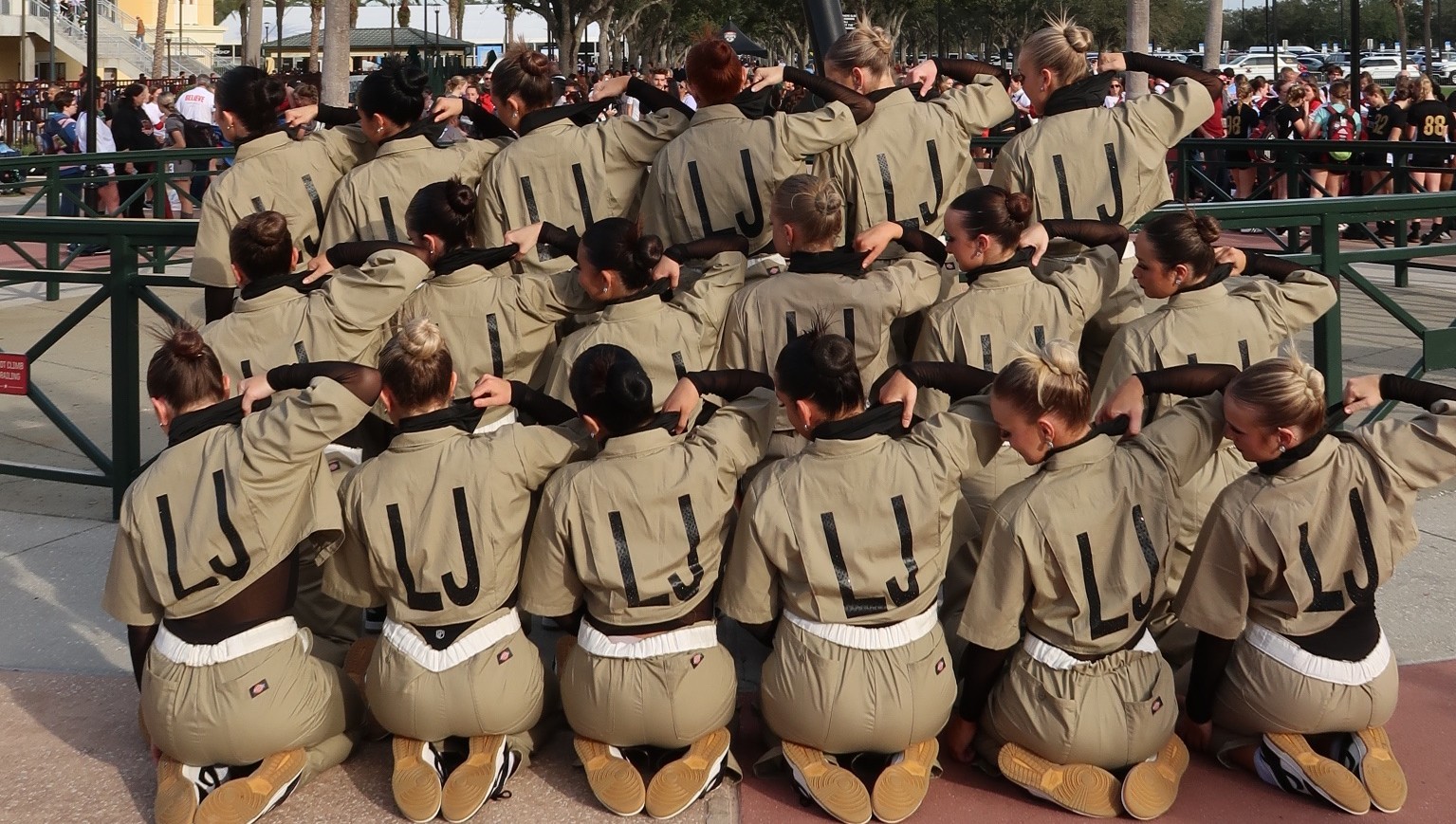 Dance team posing in beige uniforms showing off the "LJ" on the backs of their uniforms