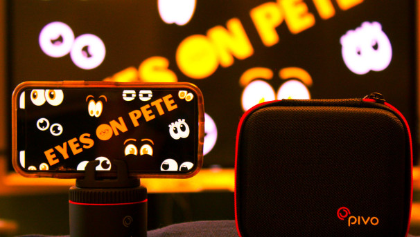 Cell phone resting in a pivo pod videoing a smart board