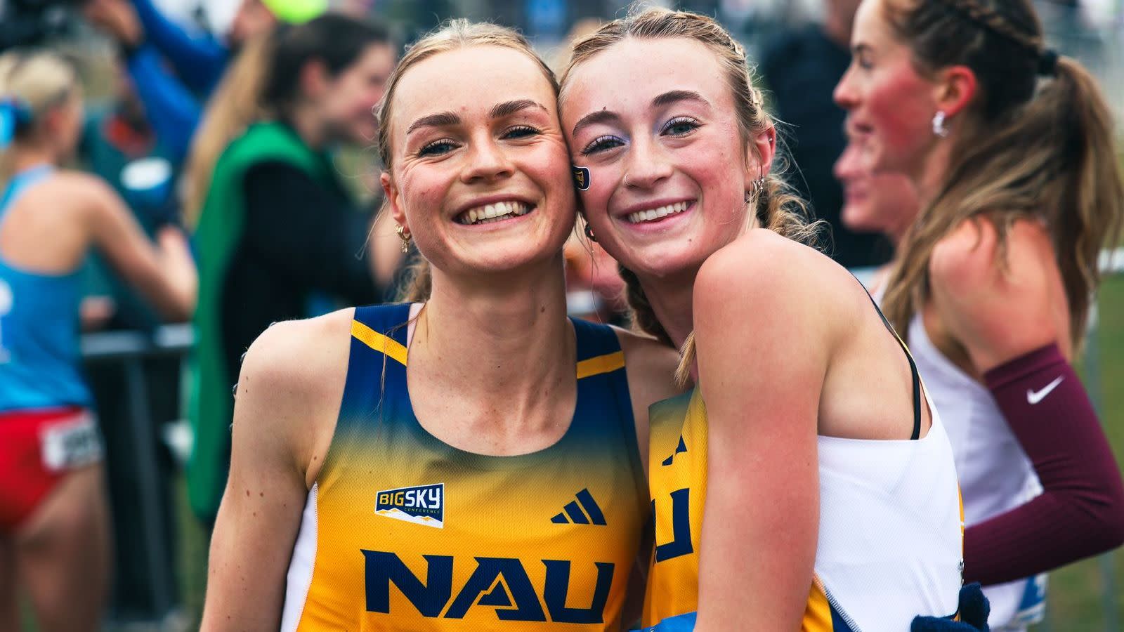 The NAU Women's Soccer team stands with their hands up in a pre-game huddle.