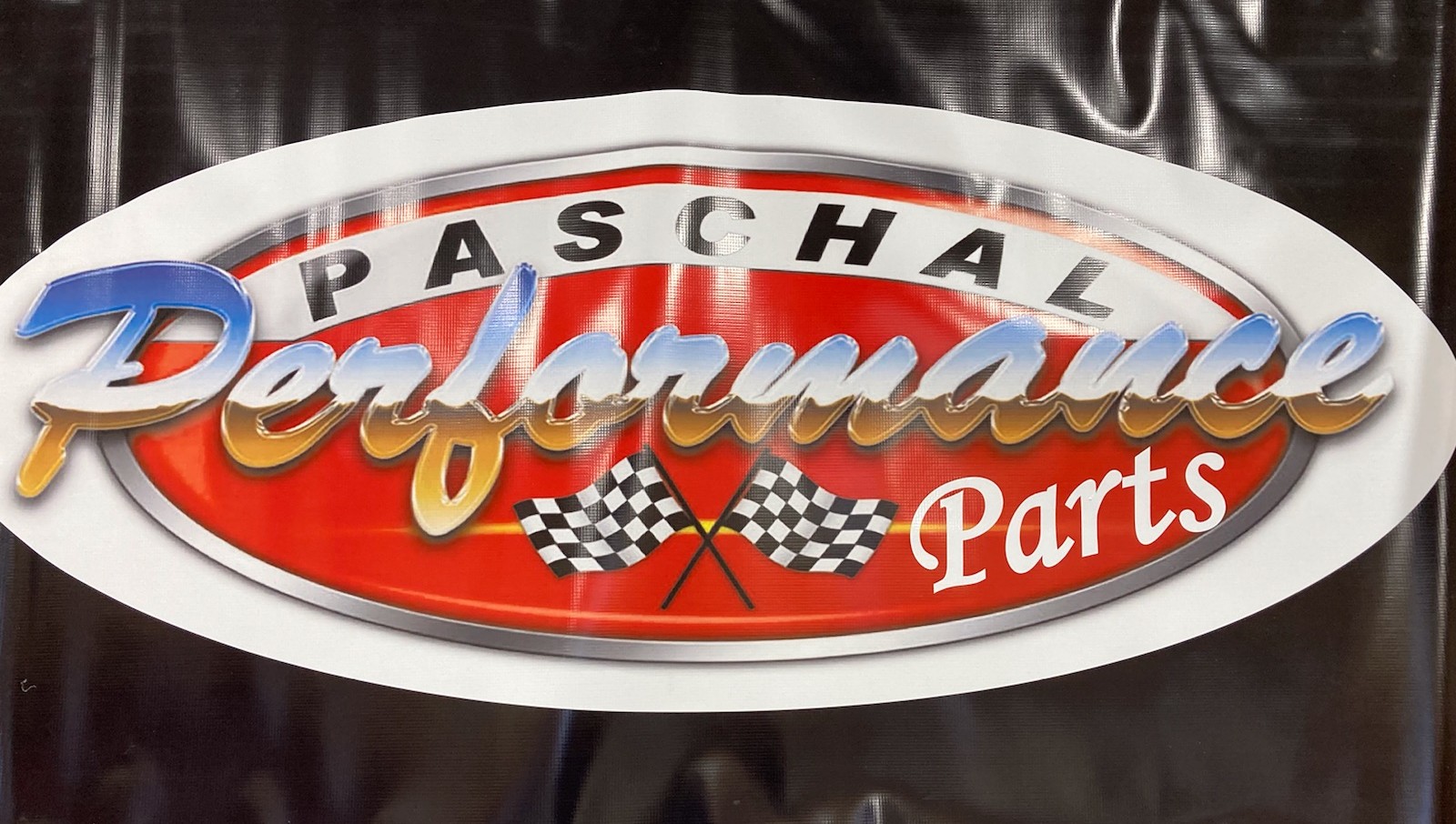 Two individuals stand outside, smiling towards the camera