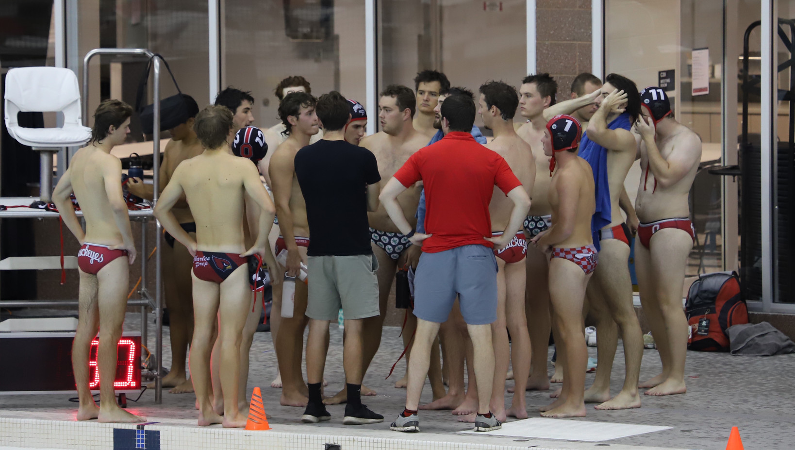 Group of Ohio State water polo players standing in a huddle talking after their game