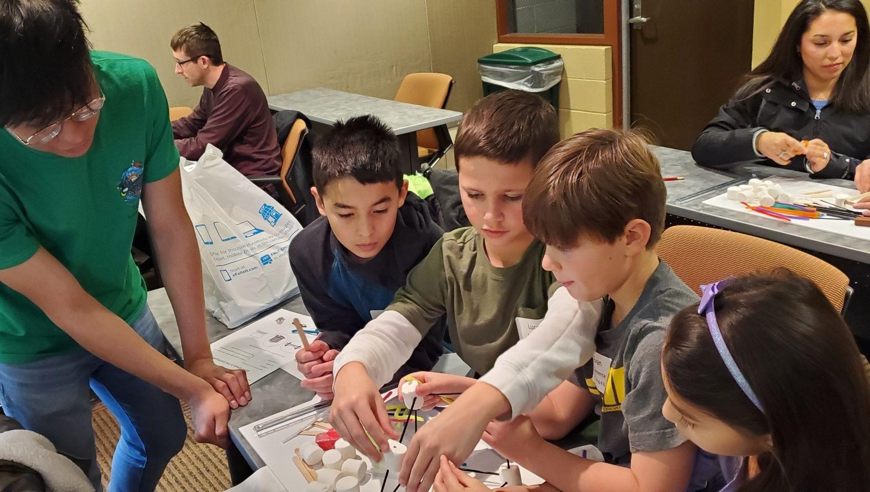 Several young students working with RPI students on a project