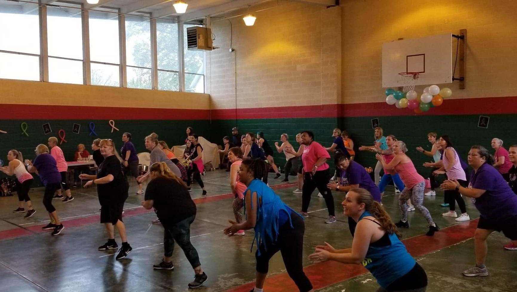 Group doing dance moves in a gym