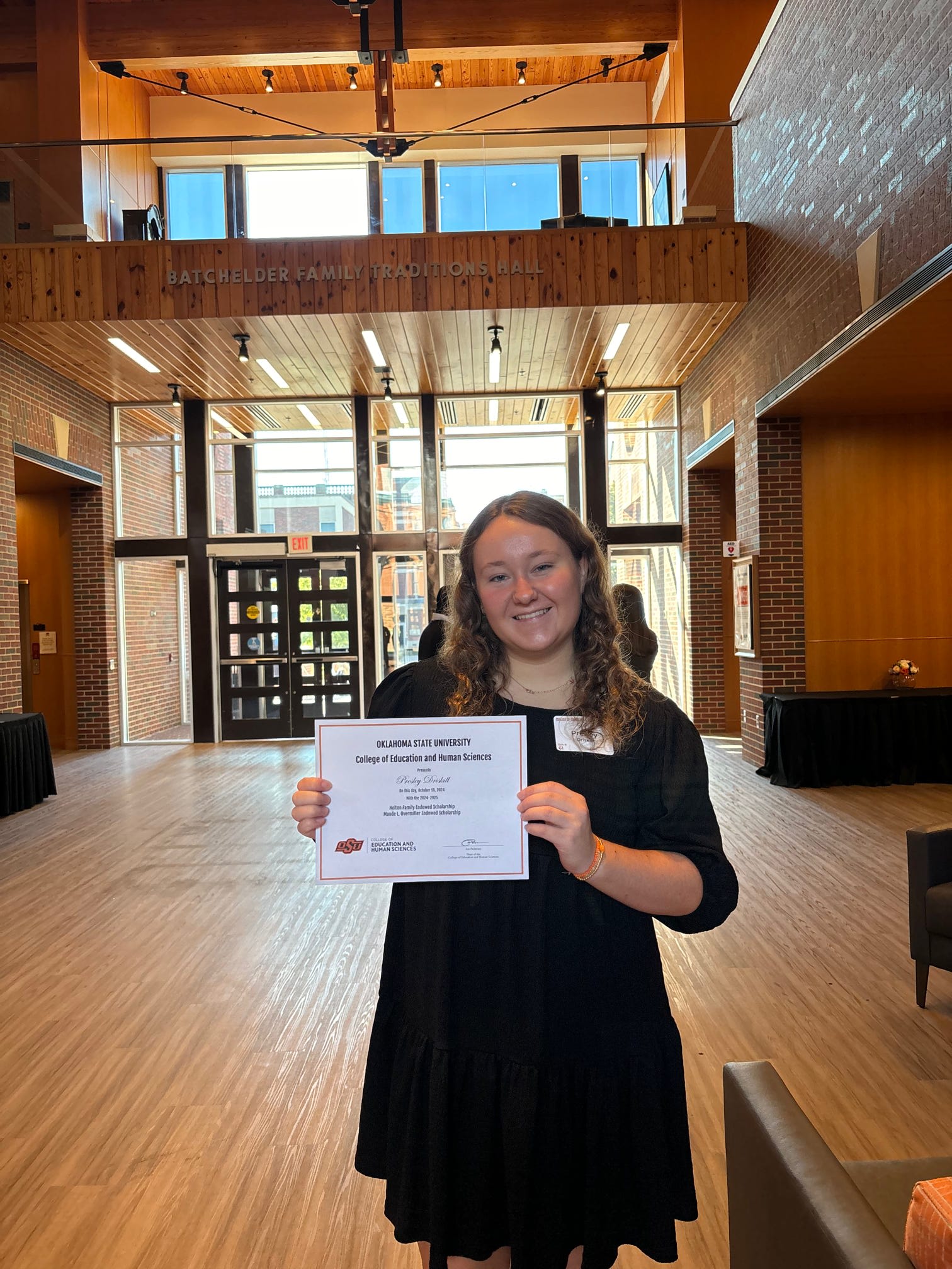 Member holding certificate for scholarship award
