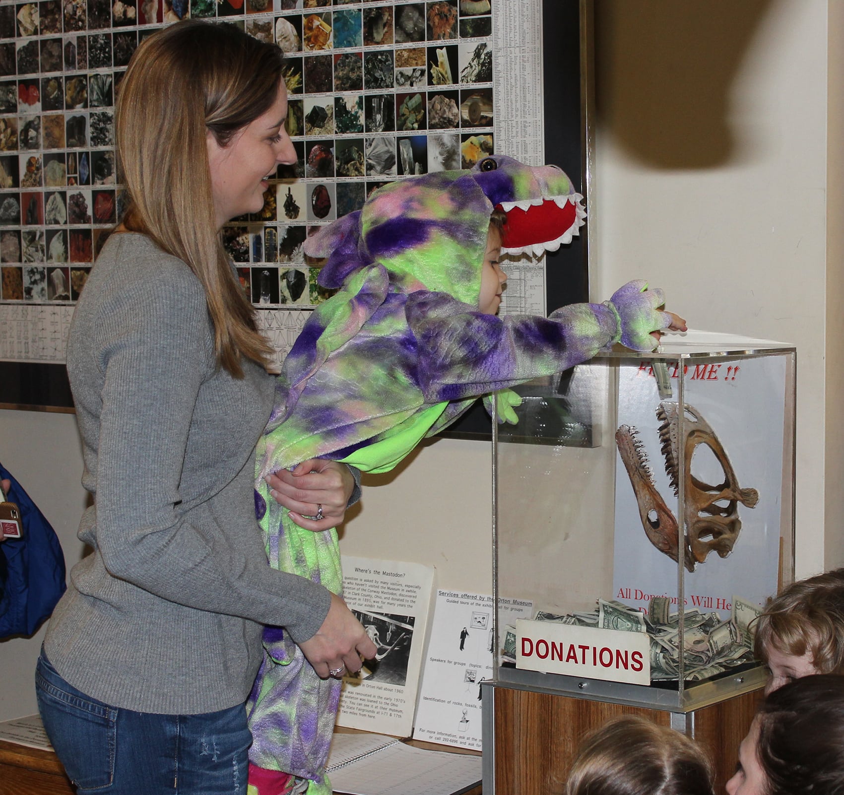A young child dropping a donation into the box
