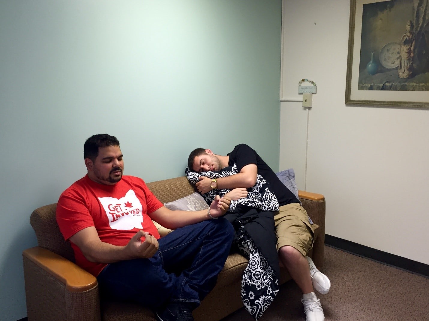Two students sit on couch, meditating and resting