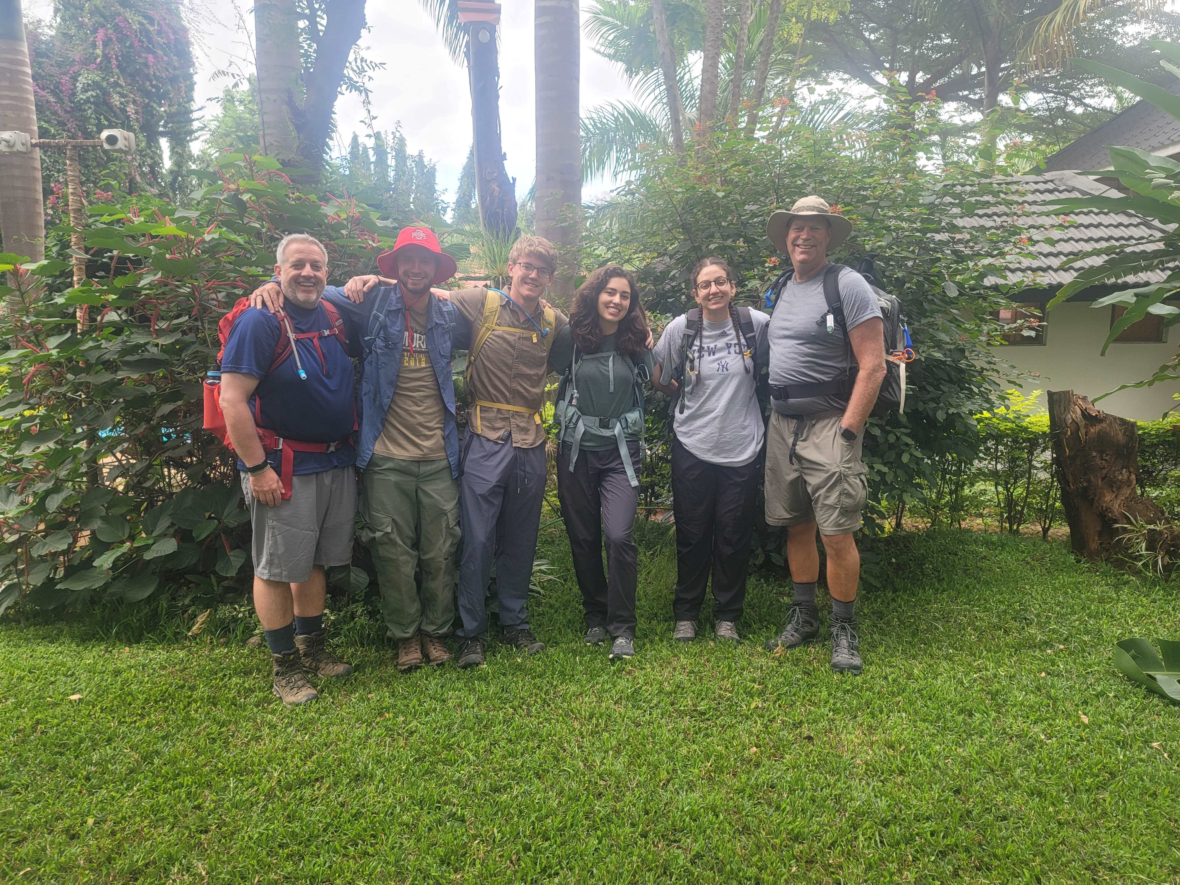 Six individuals with large backpacks, smiling