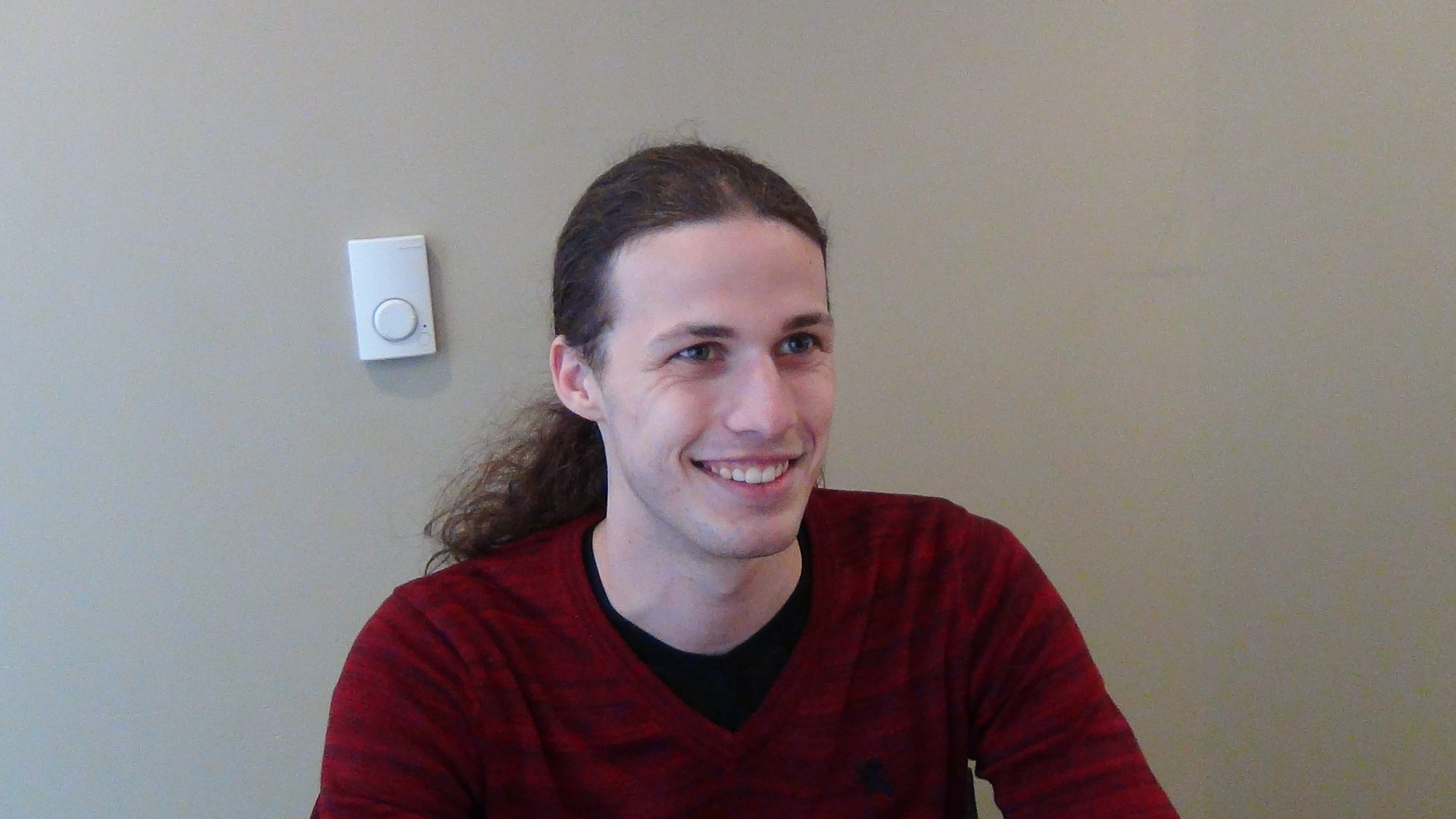 Nick smiling while looking past the camera