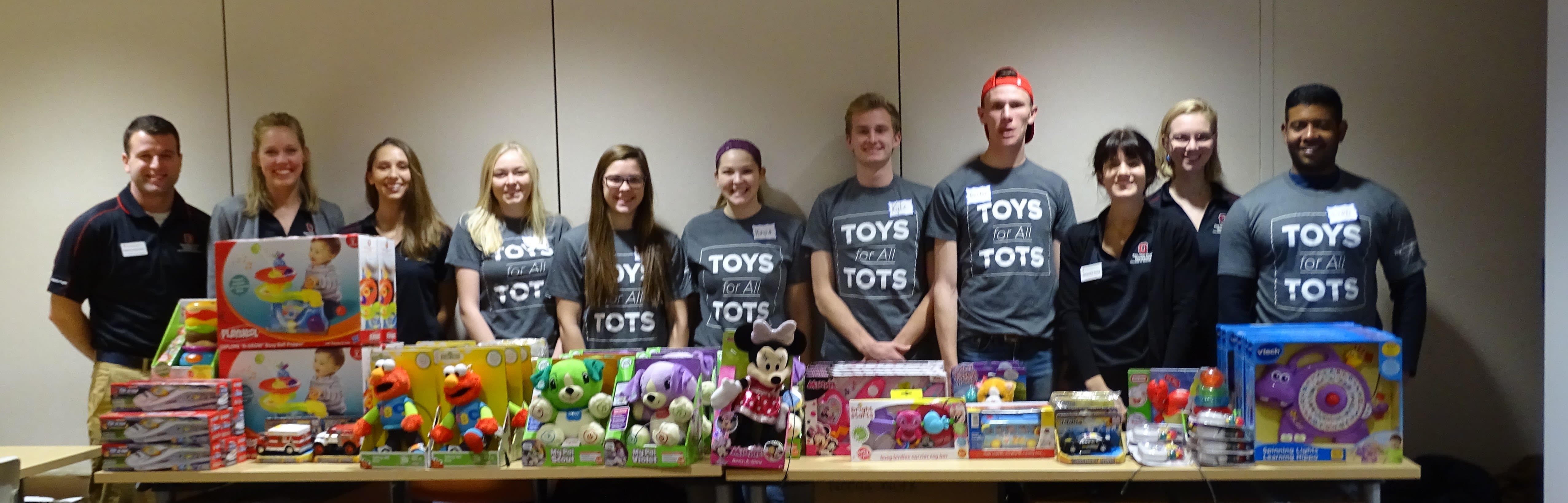A group from Toys for Tots stand behind table