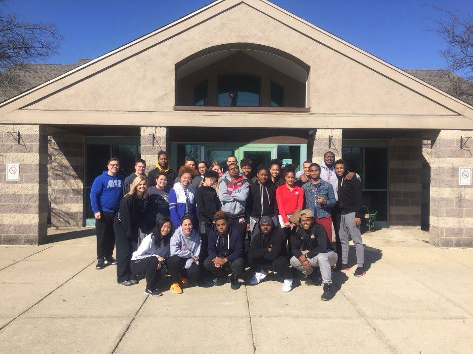 Christian McGhee and others outside a tan building