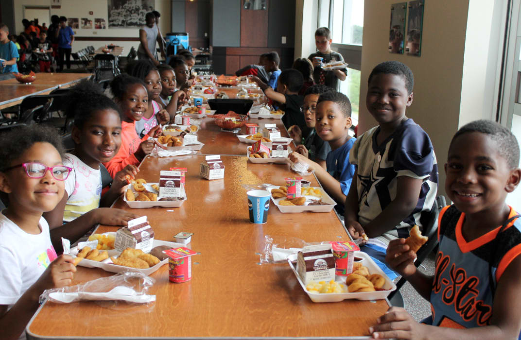 A group of children sitting at a cafeteria table