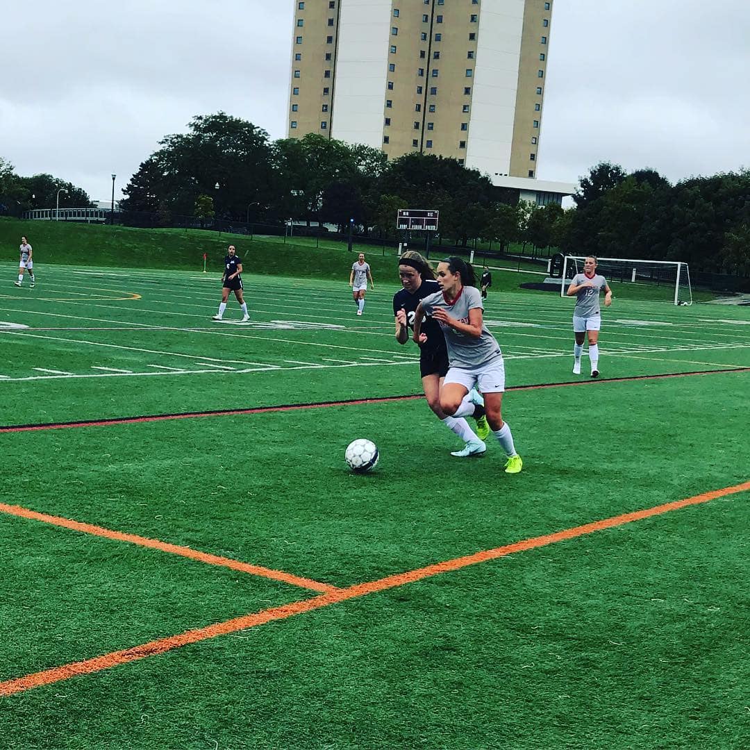 Two soccer players running after the ball