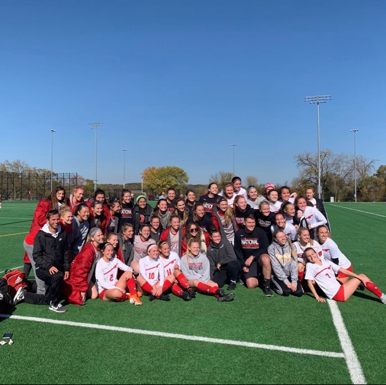 The 2019 Women's Club Soccer pose on a the field