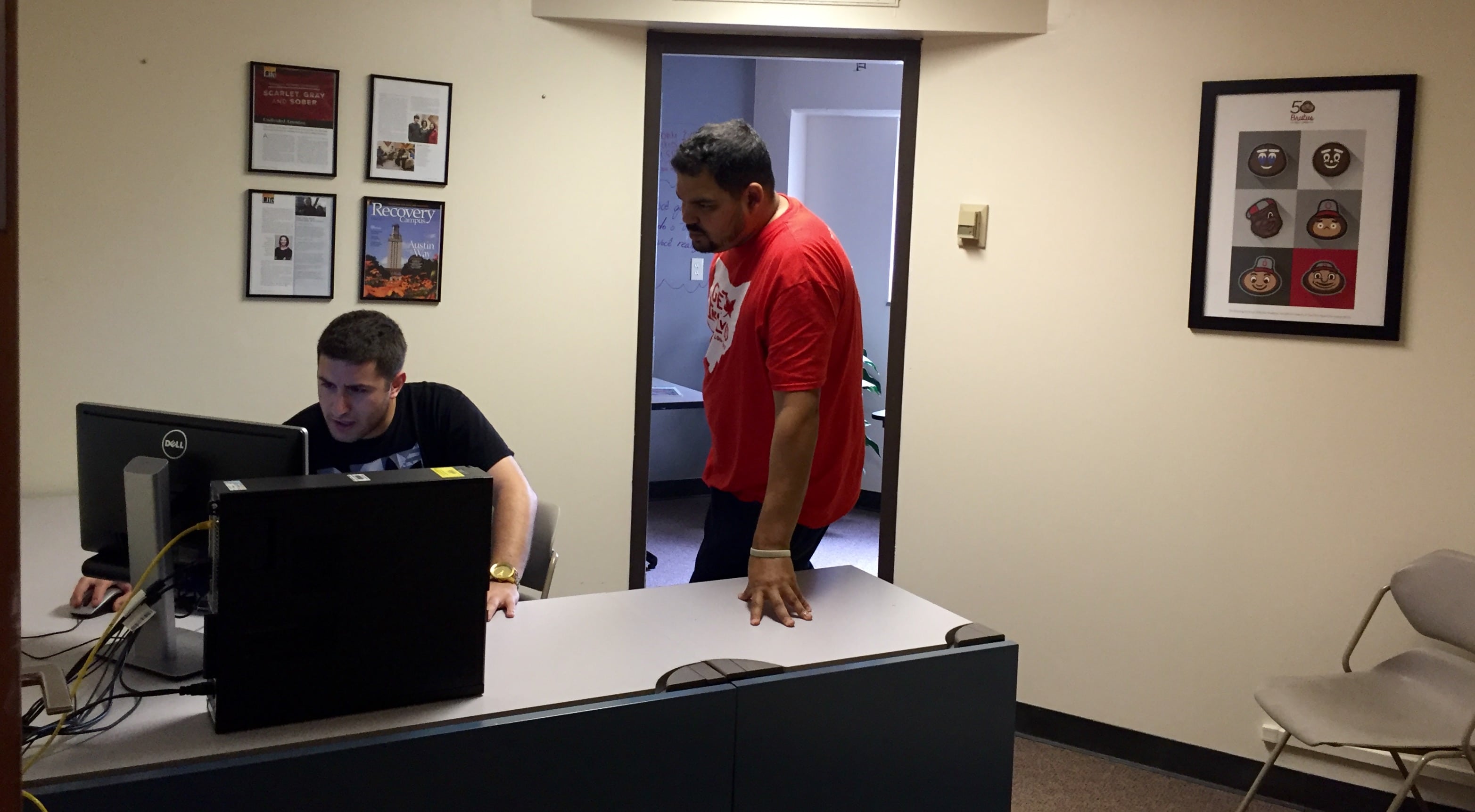 One student works at computer, the other listening