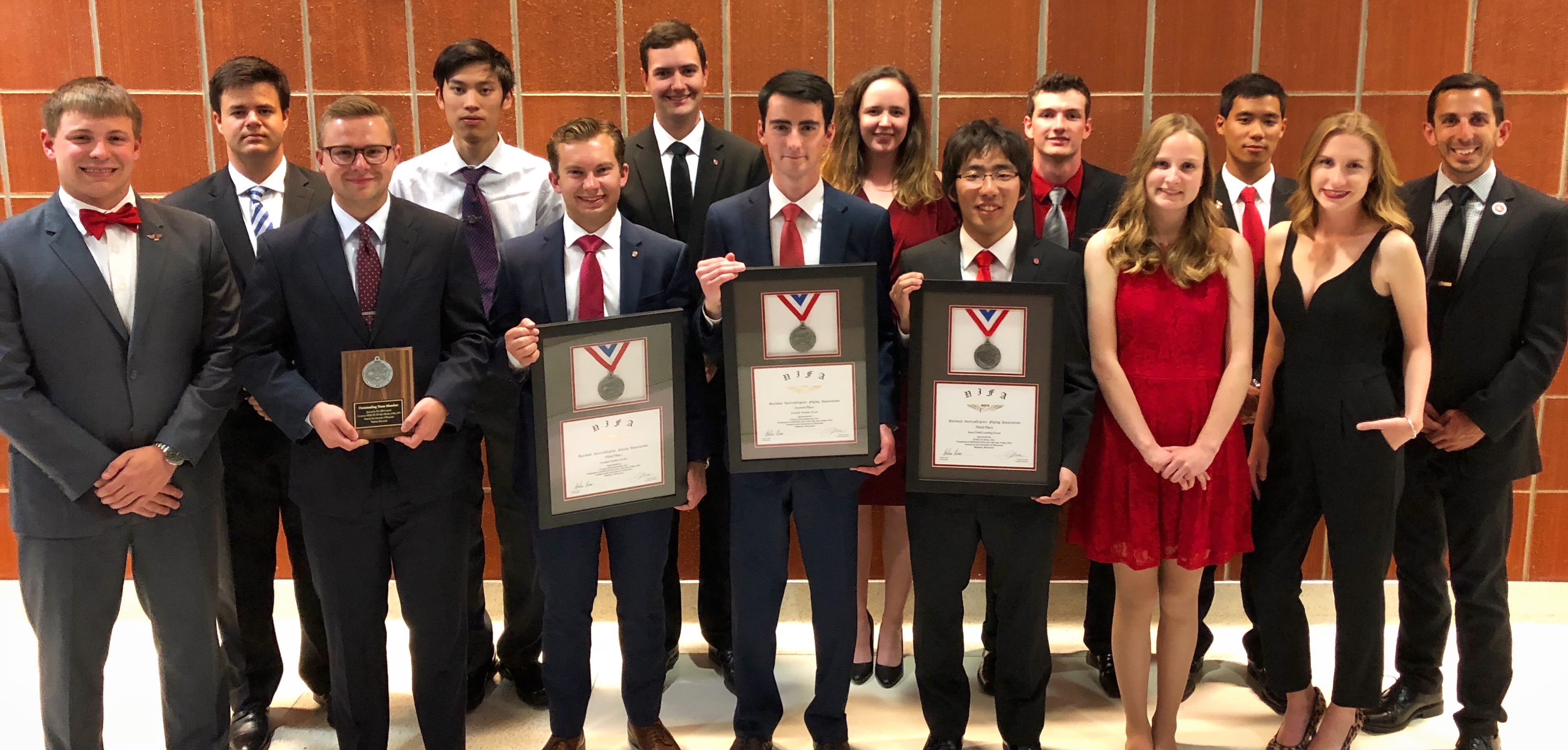 The Flight team in formal attire with plaques