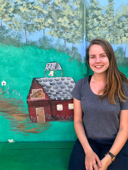 Annelise Dahl standing before a painted mural