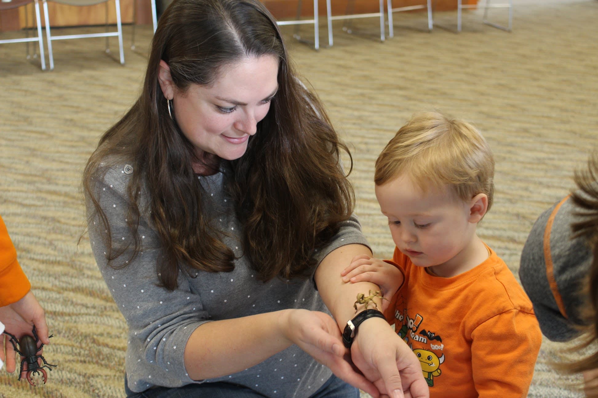 A mother and her child observing an insect