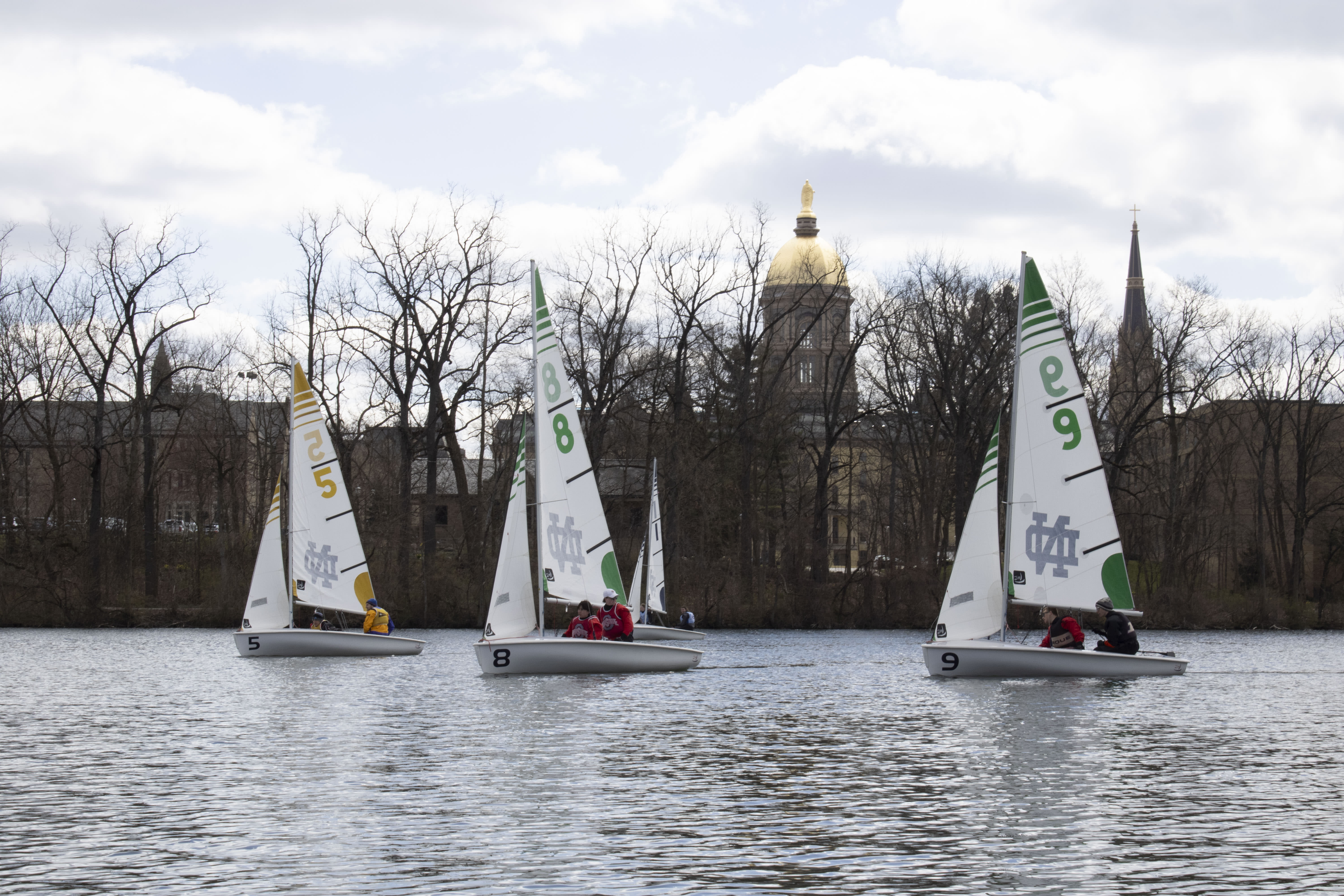 Three Notre Dame sailboats on a river