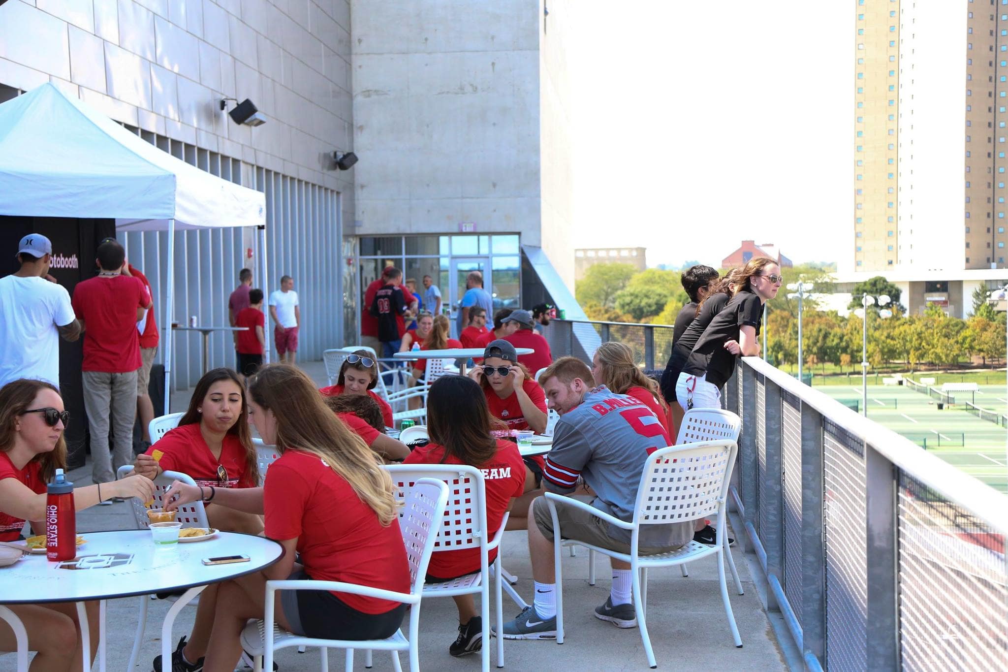 A large group sitting, sharing food and talking