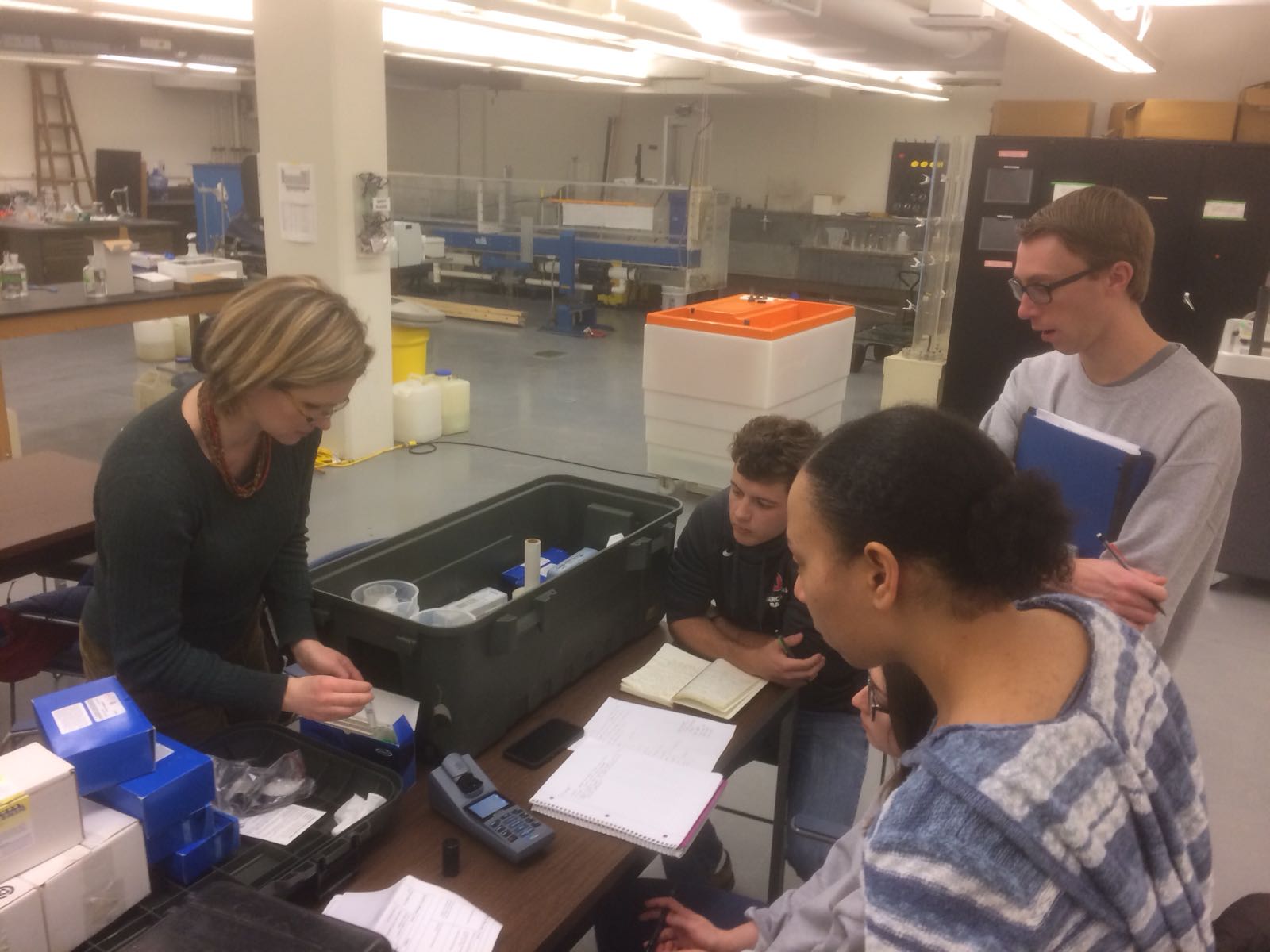 Five individuals work together at a table